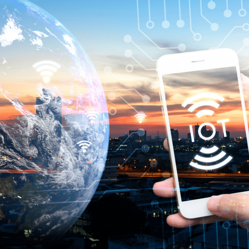Montage montrant un smartphone affichant « IOT » devant un globe et un réseau de connexions symbolisant les objets connectés