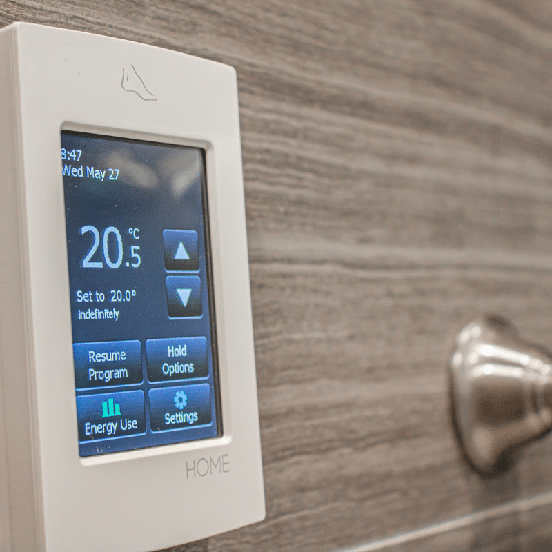 Thermostat mural à écran tactile affichant la température et les options de réglage